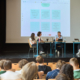 Der Politiker Heiko Droßmann diskutiert mit Schülern der Klosterschule auf der Bühne der Aula der Klosterschule